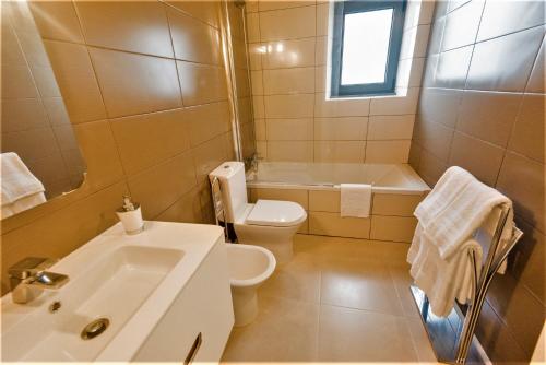 a bathroom with a sink and a toilet and a tub at Quinta do Basalto in Piedade