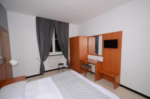 a bedroom with a bed and a desk and a window at Porta del Parco in Camogli