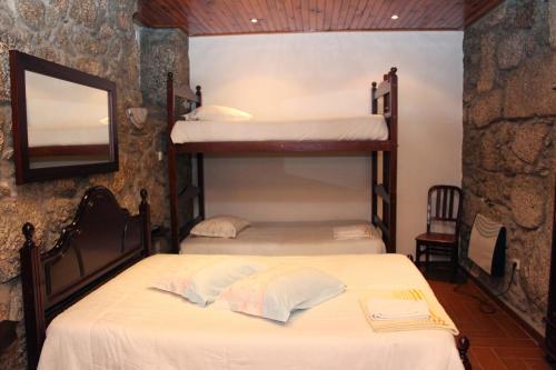 two bunk beds in a room with a mirror at Mikotania in Covilhã