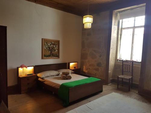 a bedroom with a bed with a teddy bear on it at Casa da Vila in Penamacor