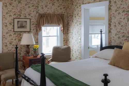 a bedroom with a bed and two chairs and a window at Dockside Guest Quarters in York