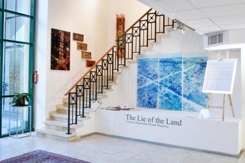 
a staircase leading up to a room with a painting on the wall at Diaghilev LOFT live art hotel in Tel Aviv
