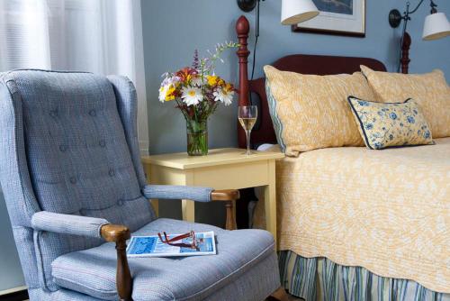 a bedroom with a bed and a chair and a vase of flowers at Dockside Guest Quarters in York