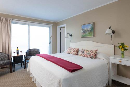 a bedroom with a white bed with a red blanket on it at Dockside Guest Quarters in York