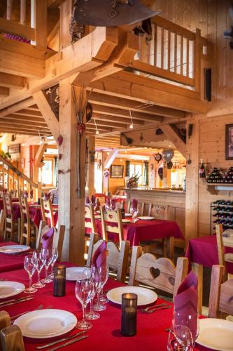 une salle à manger avec des tables, des chaises et des verres à vin dans l'établissement Hôtel L'Accroche Coeur, à La Rosière