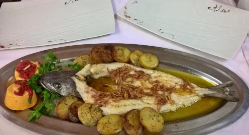 a plate of food with a fish and potatoes at ALIOS Hôtel Restaurant in Bas-Mauco