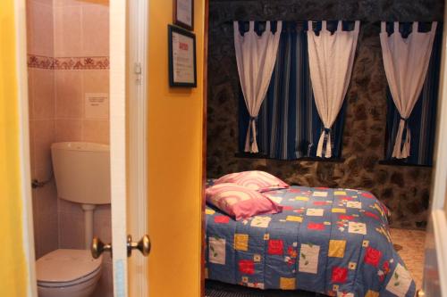 a small bedroom with a bed in a bathroom at Mikotania in Covilhã