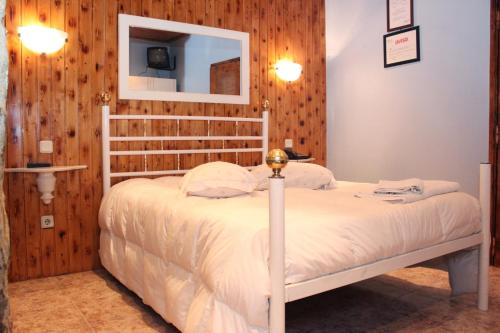 a bedroom with a white bed and a mirror at Mikotania in Covilhã