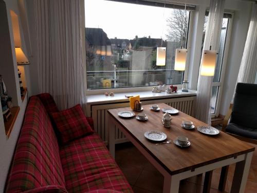 GotingにあるWhg Suedblick auf Föhrの窓のある部屋で、テーブルとソファが備わります。