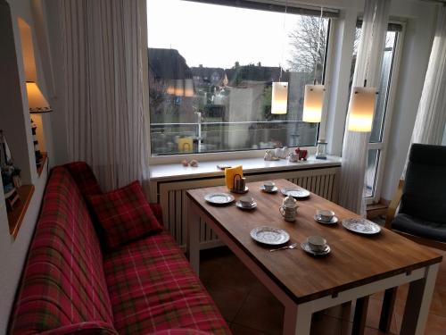 einen Tisch und ein Sofa in einem Zimmer mit Fenster in der Unterkunft Whg Suedblick auf Föhr in Goting