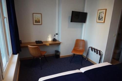 a hotel room with a desk and two chairs at Hotel Asiris in Bruges