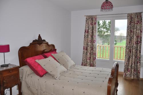 una camera da letto con letto, cuscini e finestra di la grange aux hirondelles a Athienville