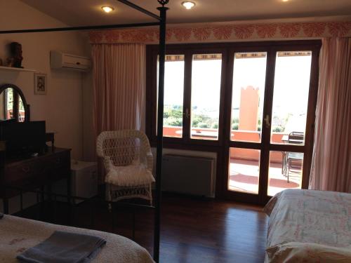 a bedroom with a bed and a sliding glass door at Al Sandalyon in Quartu SantʼElena