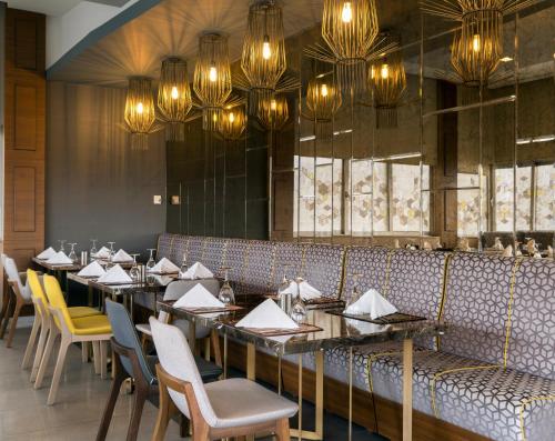 a dining room with tables and chairs and chandeliers at Radisson Blu Ankara in Ankara
