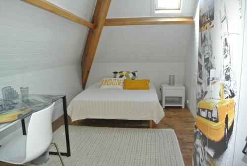 Un dormitorio pequeño con una cama y un escritorio. en Domaine de Bellevue, en Beaupuy