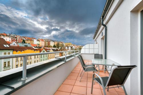 a balcony with a table and chairs on a building at DownTown Suites Belohorska in Prague