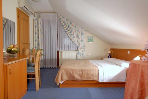 Habitación de hotel con cama, escritorio y mesa. en Guesthouse Bajc, en Vrhnika