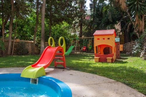 un parque infantil con tobogán y una casa de juguetes en Blue Sea Al Andalus, en Torremolinos