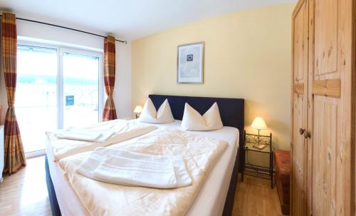 a bedroom with a large white bed with a window at Haus Ohragrund in Oberhof