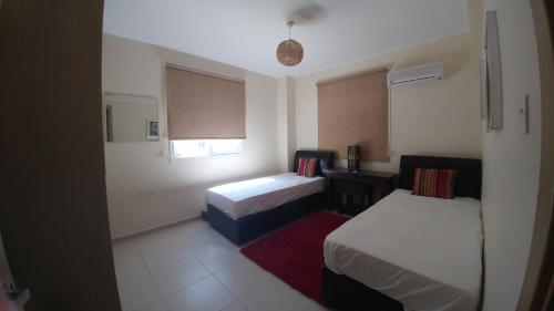 a small room with two beds and a window at Pyla Gardens A102 in Pyla