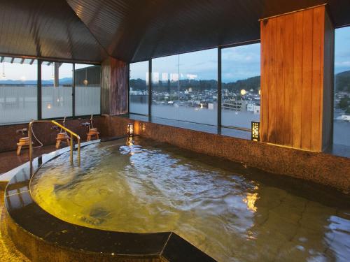 a large pool of water in a room with windows at Honjin Hiranoya Kachoan in Takayama