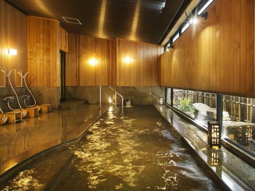 a large pool of water in a room with wooden cabinets at Honjin Hiranoya Kachoan in Takayama