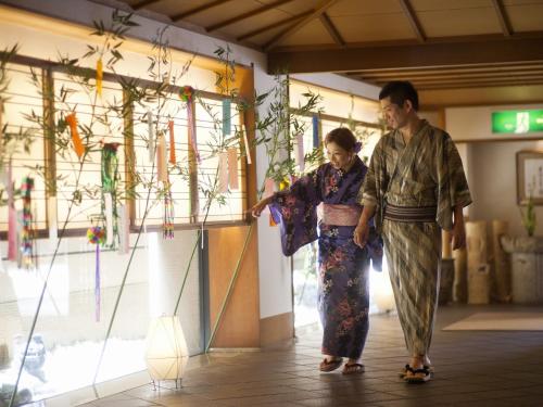 a man and a woman standing in a store at Honjin Hiranoya Kachoan in Takayama