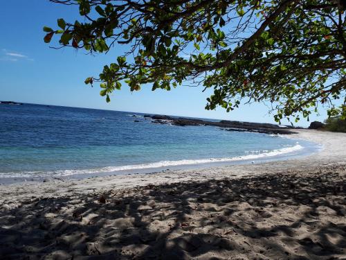 a sandy beach with the ocean in the background at Chalet San Juanillo in San Juanillo