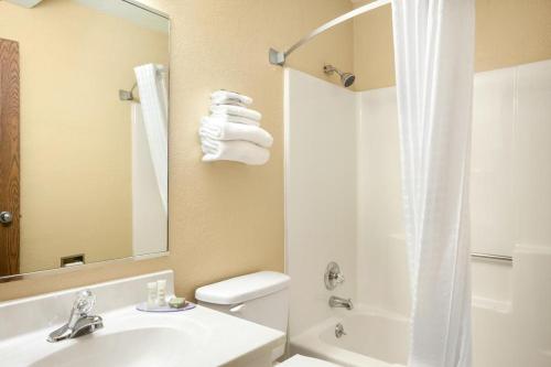 y baño con lavabo, aseo y ducha. en Super 8 by Wyndham Burlington, en Burlington