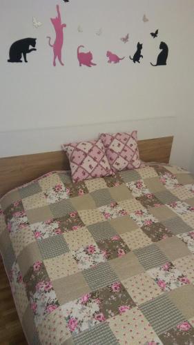 una camera da letto con un letto con una trapunta e cuscini di Apartment Burence a Novi Sad