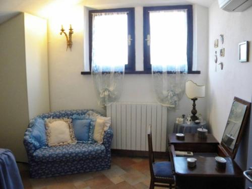 a living room with a chair and a table at La Casa di Gigliola in Monticiano