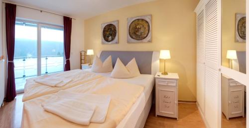 a bedroom with a large white bed with a window at Apartment Ohragrund in Oberhof