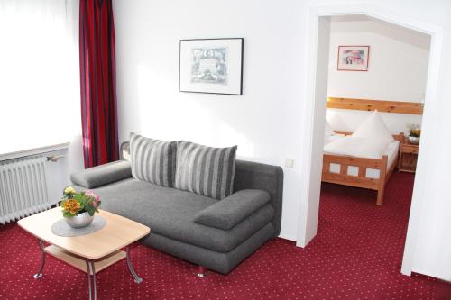 a living room with a couch and a bed at Hotel an der Sonne & Restaurant Zum Schneiger in Schonwald im Schwarzwald