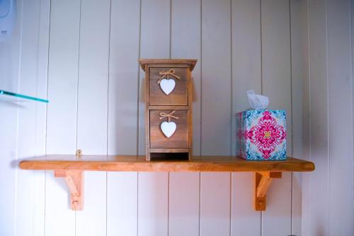 a shelf with two wooden boxes and a box at Storws Y Gorlan Shepherd's Hut in Valley