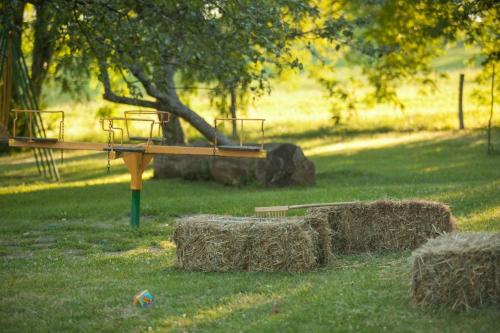 a playground with hay bales in a field at Janezinovi House in Ratečevo Brdo