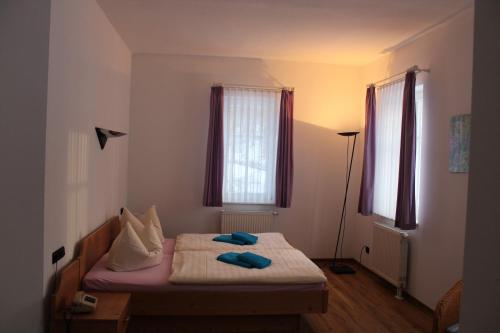 a bedroom with a bed with two blue pillows on it at Hotel Waldhaus in Römhild