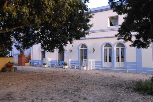 a blue and white building with chairs in front of it at Quinta de Coalhos TH in Abrantes