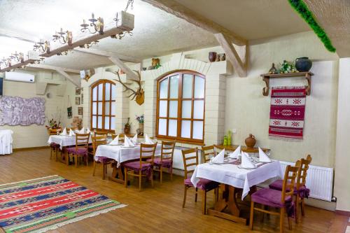 a dining room with white tables and purple chairs at Hotel BACHUS in Chişinău