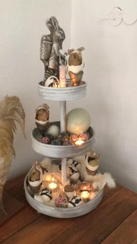 a three tiered display with candles and dolls on a shelf at Das Kleine Hotel Schleiblick in Schleswig