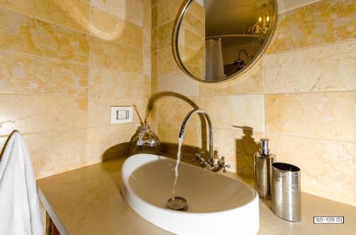 a white sink in a bathroom with a mirror at Naomi's in Rosh Pinna