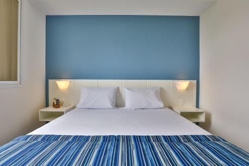 a bedroom with a large bed with two night stands at Transamerica Fit Jacareí in Jacareí