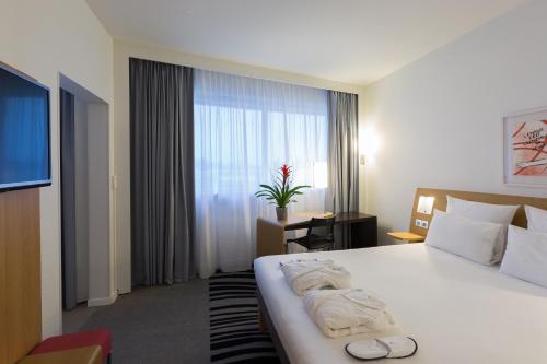 Postel nebo postele na pokoji v ubytování Novotel Poitiers Site du Futuroscope