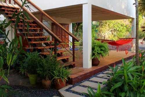 a house with a staircase and a porch with plants at Cabañas La Casa de Pucha in Pedasí Town