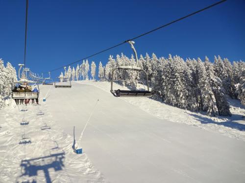 a ski lift on a snow covered ski slope at Ferienwohnung Schneemann in Hohegeiß