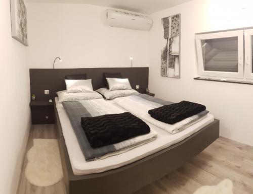 a bedroom with a large bed with black and white sheets at Villa Gina in Sevid