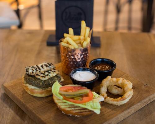 a wooden tray with a sandwich and french fries and dips at The View in Welwyn Garden City