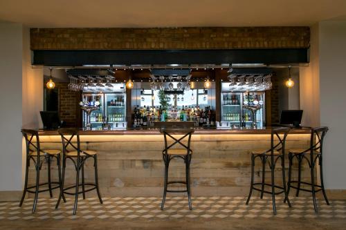 a bar with four bar stools in front of it at The View in Welwyn Garden City