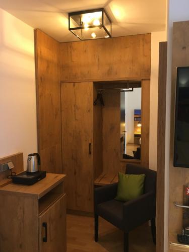 a room with a chair and a table and a mirror at Parkhotel Leiser in Planegg