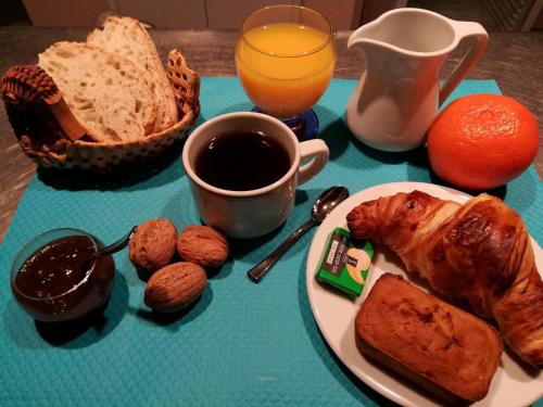 une table avec une assiette de pain et une tasse de café dans l'établissement Les Chalets d'Argentouleau, à Sarlat-la-Canéda