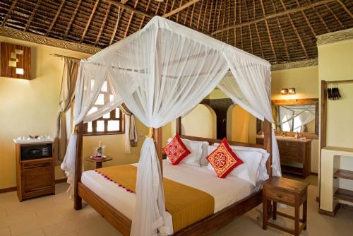 a bedroom with a bed with a canopy at The Island - Pongwe Lodge in Pongwe